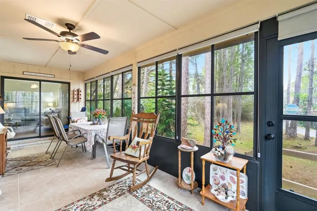 a house that has a big yard large trees with plants in front of it