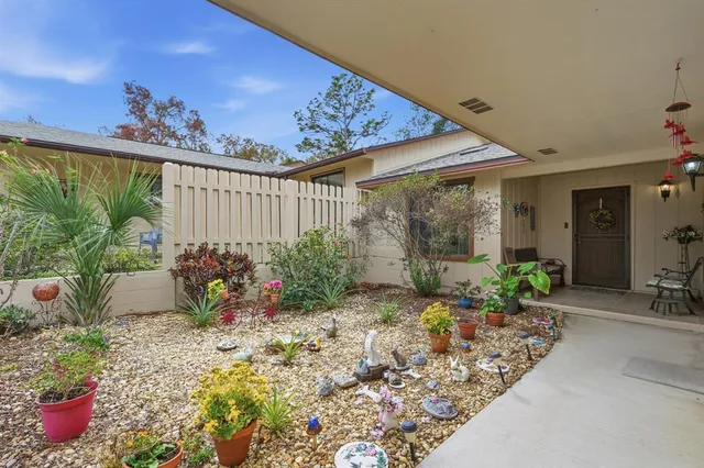 a view of a porch with table and chairs potted plants