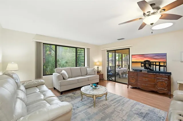 a living room with furniture a flat screen tv and a large window