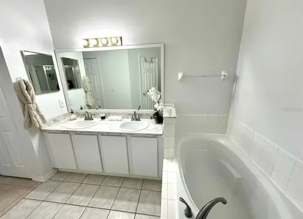 a bathroom with a bathtub sink vanity and mirror