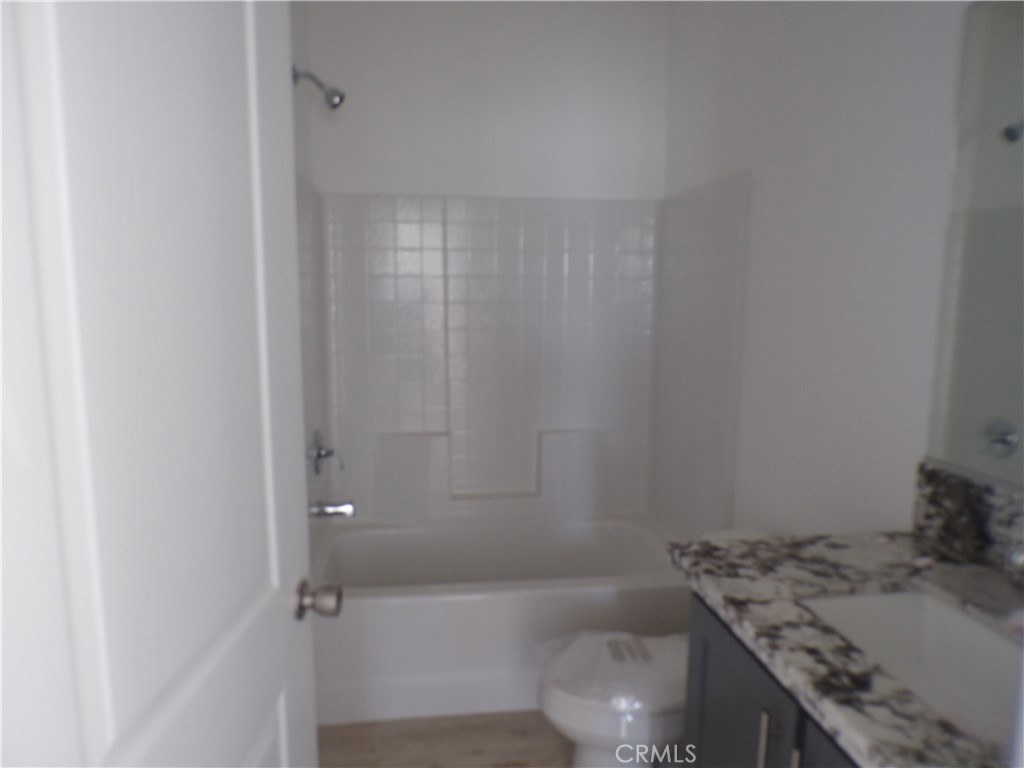 15305 Trinity Road Cobb, CA 95426 - Photo 12 of 12 a bathroom with a granite countertop sink a toilet and bathtub