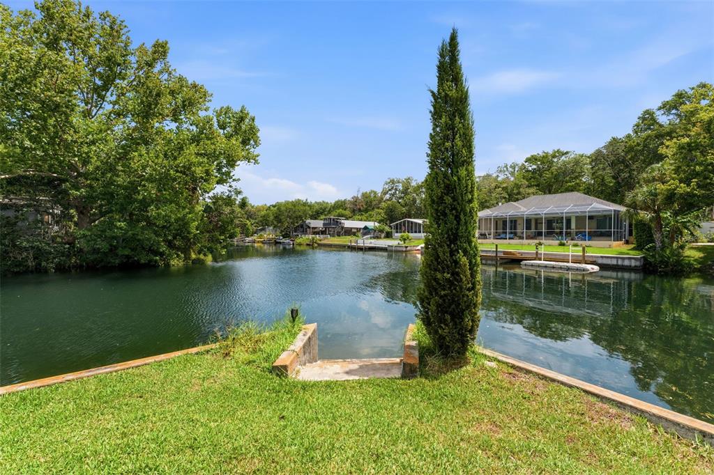 6355 Sebring Street Weeki Wachee, FL 34607 - Photo 3 of 65 a view of a lake with a house in the background