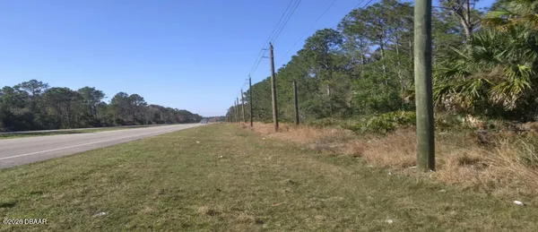 a view of a field with trees in the background
