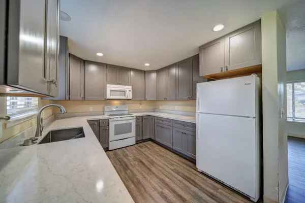 a kitchen with granite countertop a refrigerator stove and sink