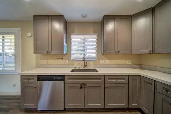 a kitchen with stainless steel appliances granite countertop a sink and cabinets with wooden floor