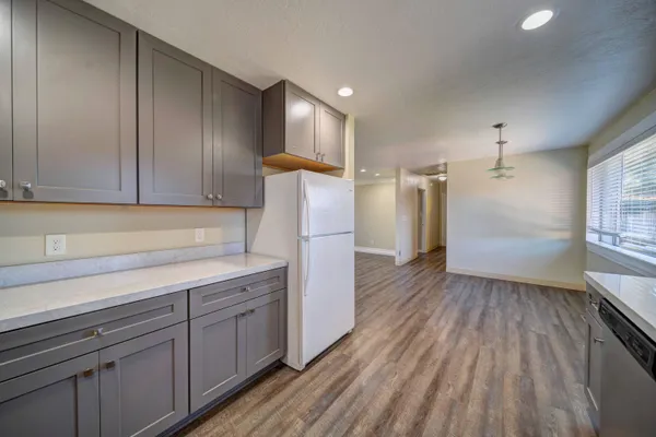 a kitchen with a sink a refrigerator and wooden floor