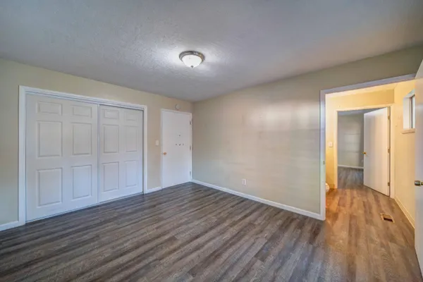 a view of an empty room with wooden floor