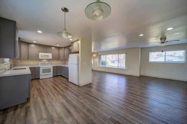 a view of a kitchen with lot of cabinets and wooden floor