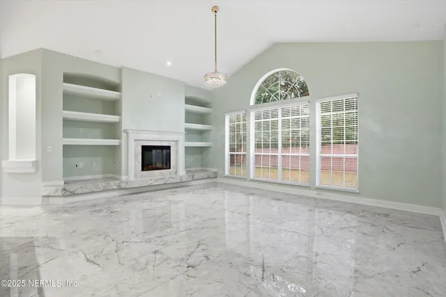 a view of an empty room with a fireplace and a window