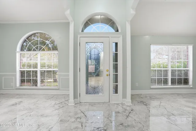 an empty room with wooden floor windows and outdoor view