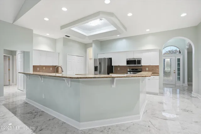 a kitchen with stainless steel appliances granite countertop a refrigerator and a sink