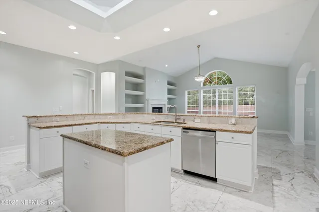 a kitchen with stainless steel appliances granite countertop a sink and a stove