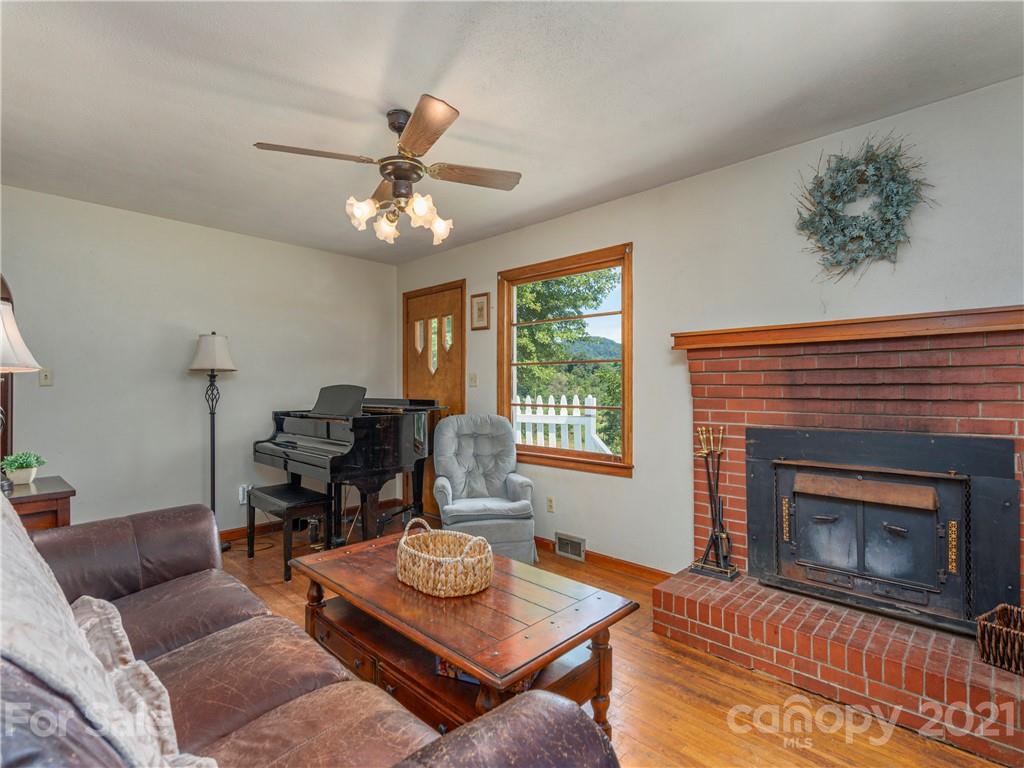 358 Coffee Branch Road Canton, NC 28716 - Photo 7 of 19 a living room with furniture a fireplace and a window