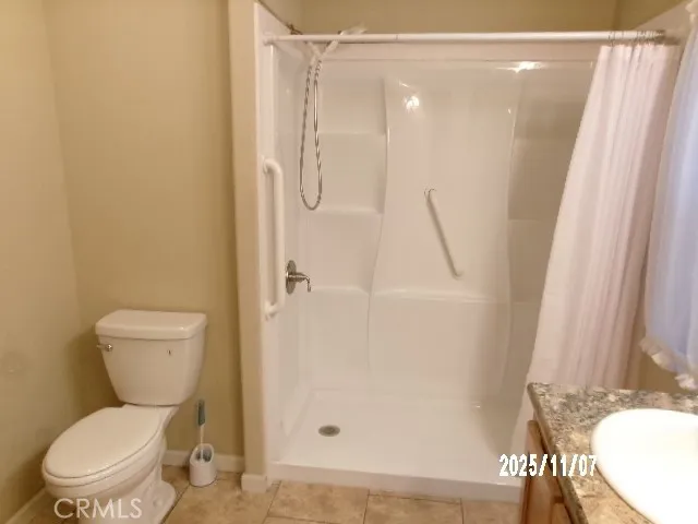 a white toilet sitting next to a shower