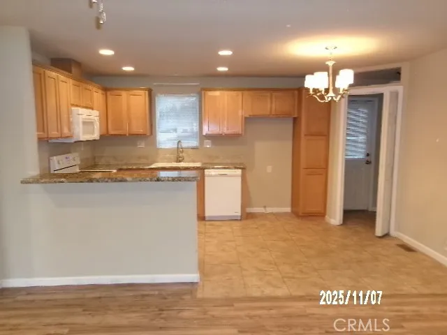 a view of kitchen with granite countertop cabinets and refrigerator
