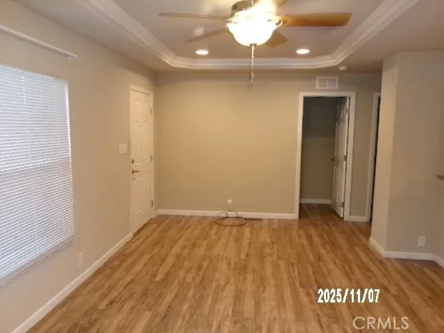 an empty room with wooden floor and chandelier fan