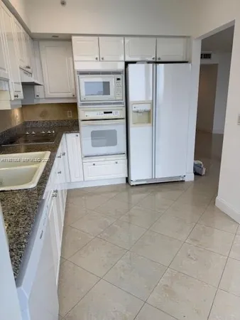 a kitchen with a stove a refrigerator and cabinets
