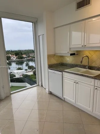 a kitchen with granite countertop white cabinets and a sink