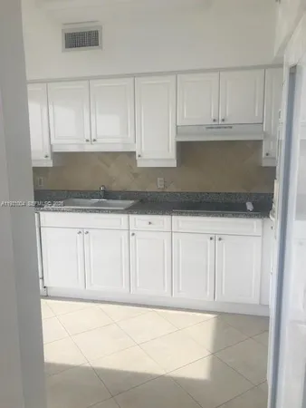 a kitchen with white cabinets and a sink