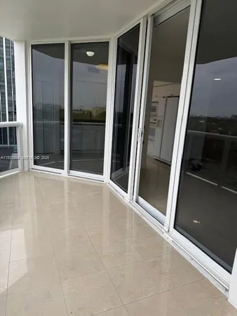 an empty room with sliding door and a floor to ceiling window
