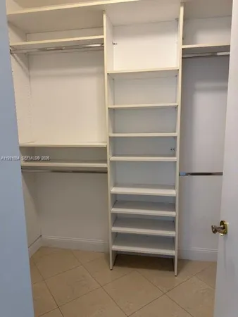 a view of walk in closet with empty racks