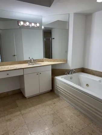 a spacious bathroom with a tub sink and mirror