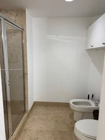 a bathroom with a toilet and a shower
