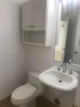 a white toilet sitting next to a white sink