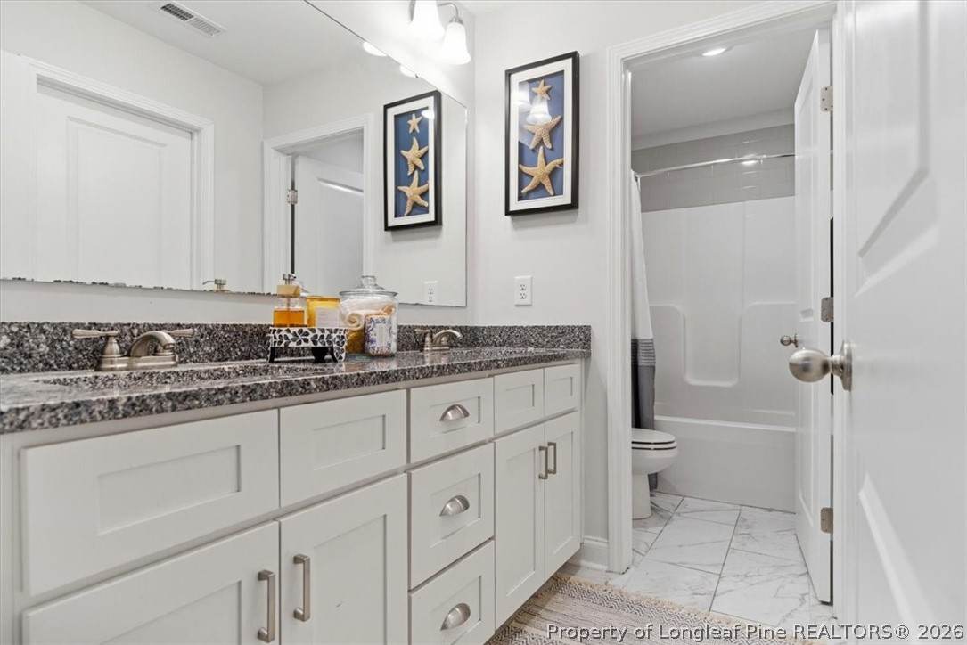 339 Rocking Horse Lane Raeford, NC 28376 - Photo 33 of 47 a bathroom with a granite countertop sink mirror vanity and toilet