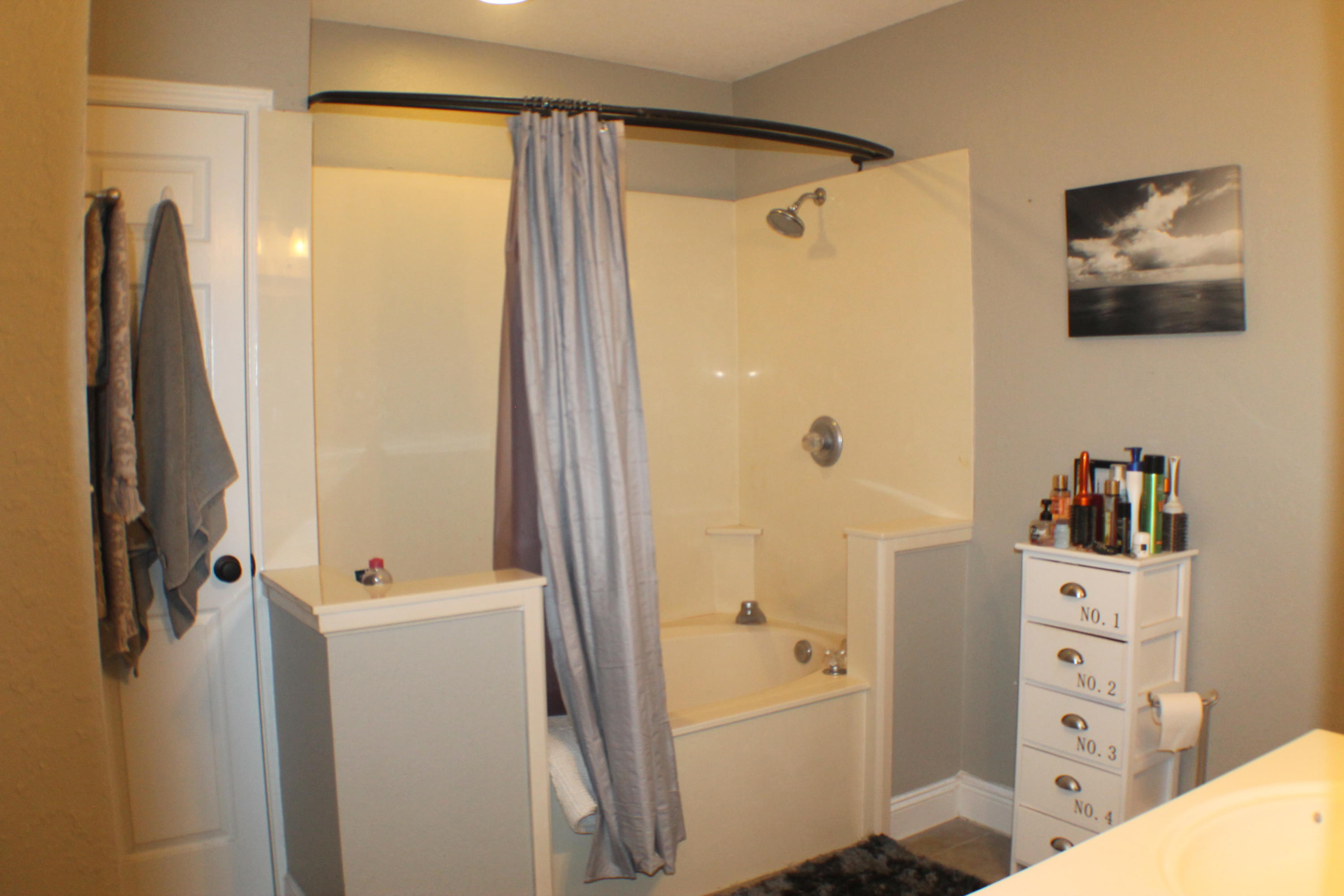 5843 Dairy Road Baker, FL 32531 - Photo 21 of 37 a bathroom with a shower a sink and a mirror