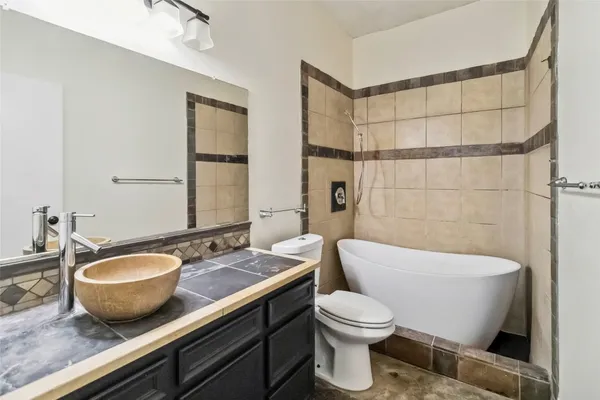a bathroom with a sink a toilet a mirror and bathtub
