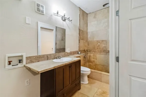 a bathroom with a sink and mirror with toilet