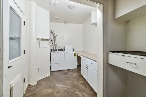 a utility room with cabinets washer and dryer