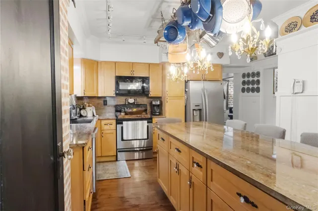 a kitchen with kitchen island granite countertop a sink appliances cabinets and a counter top space