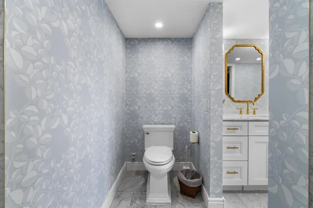 a bathroom with a toilet a sink and mirror