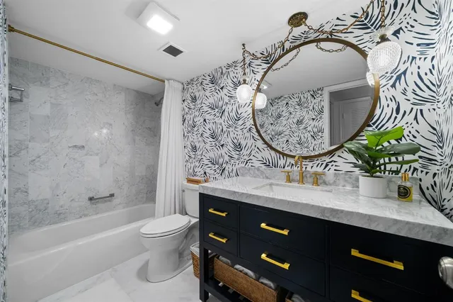 a bathroom with a granite countertop sink a toilet and bathtub