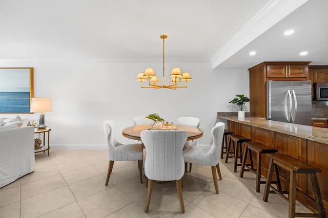 a dining room with furniture a chandelier and kitchen view