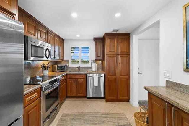 a kitchen with stainless steel appliances granite countertop a stove a sink and a refrigerator