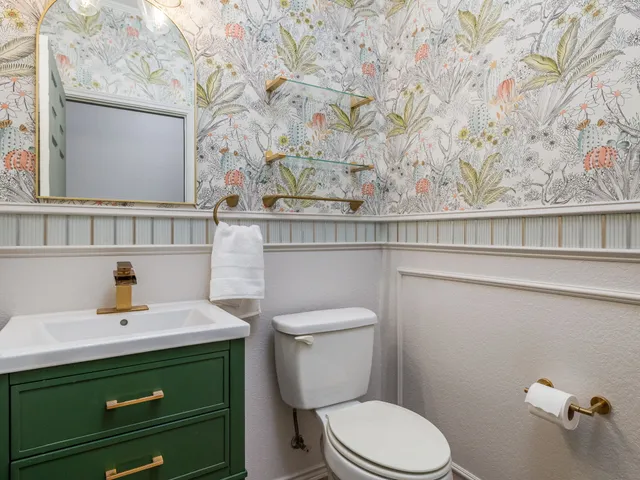 a bathroom with a toilet sink and mirror