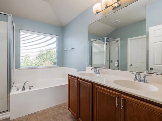 a bathroom with a granite countertop sink mirror and a bathtub