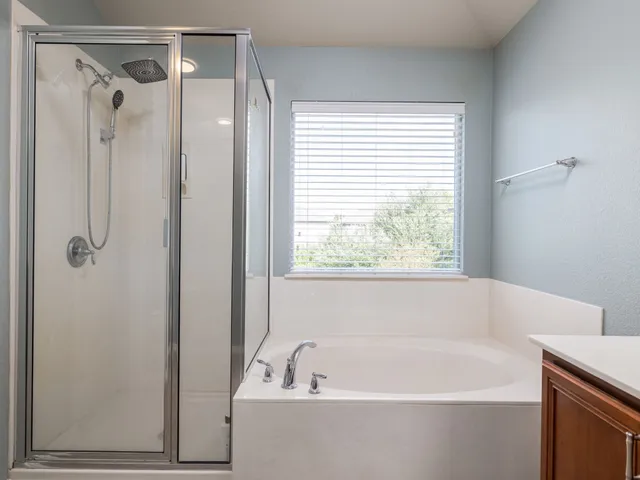 a white bath tub sitting next to a shower