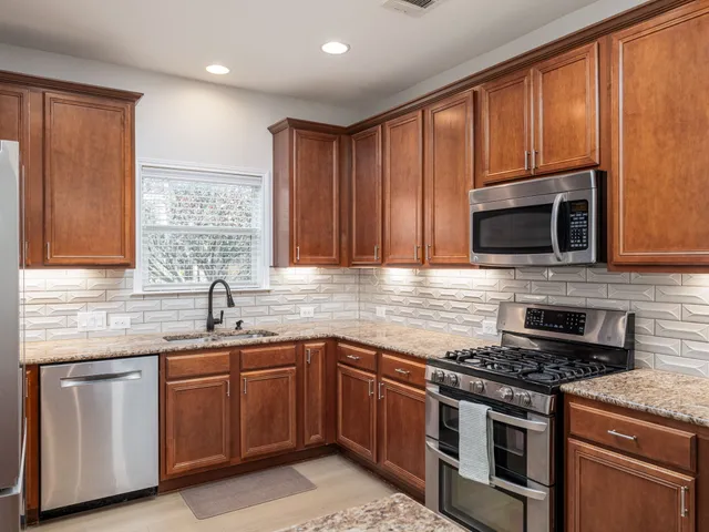 a kitchen with stainless steel appliances granite countertop a stove sink microwave and cabinets