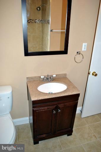 2820 Greenlawn Road Baltimore, MD 21207 - Photo 14 of 26 a bathroom with a sink a toilet and mirror