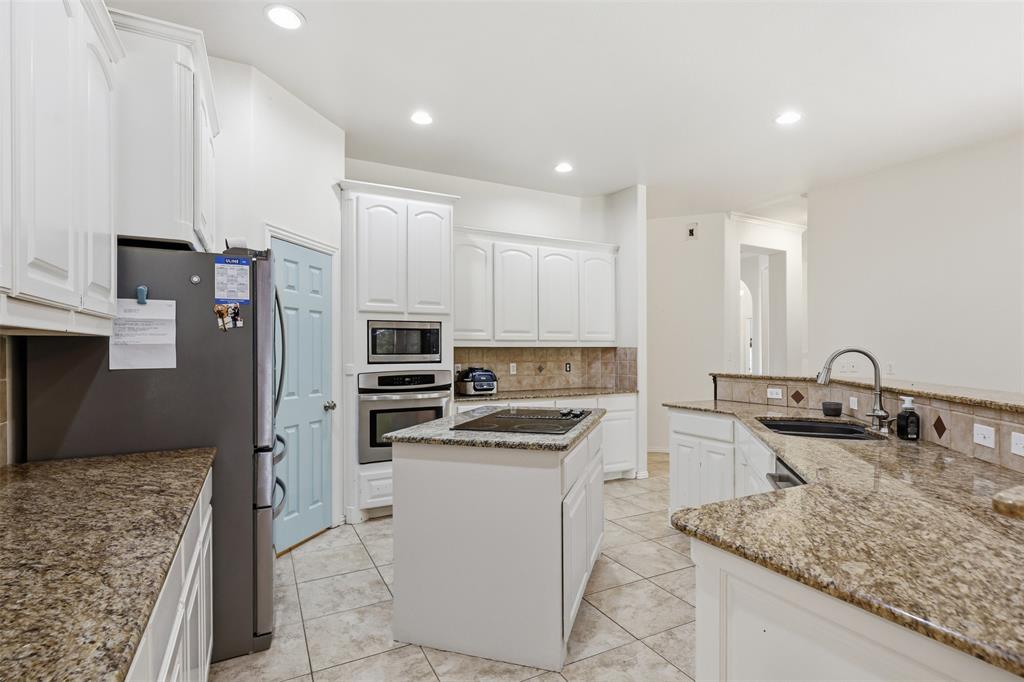 4417 Slayton Road Cleburne, TX 76031 - Photo 17 of 28 Bright kitchen featuring white cabinetry and granite countertops