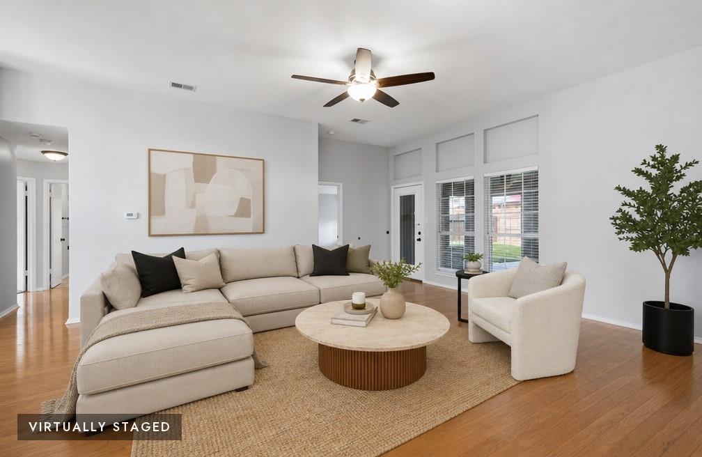 2074 Briarcliff Road Lewisville, TX 75067 - Photo 2 of 40 Light-filled living area featuring wood-finish flooring, a ceiling fan, and large windows with horizontal blinds - virtually staged