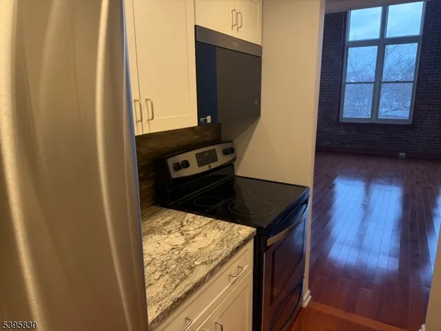 a kitchen with stainless steel appliances granite countertop a refrigerator and a stove