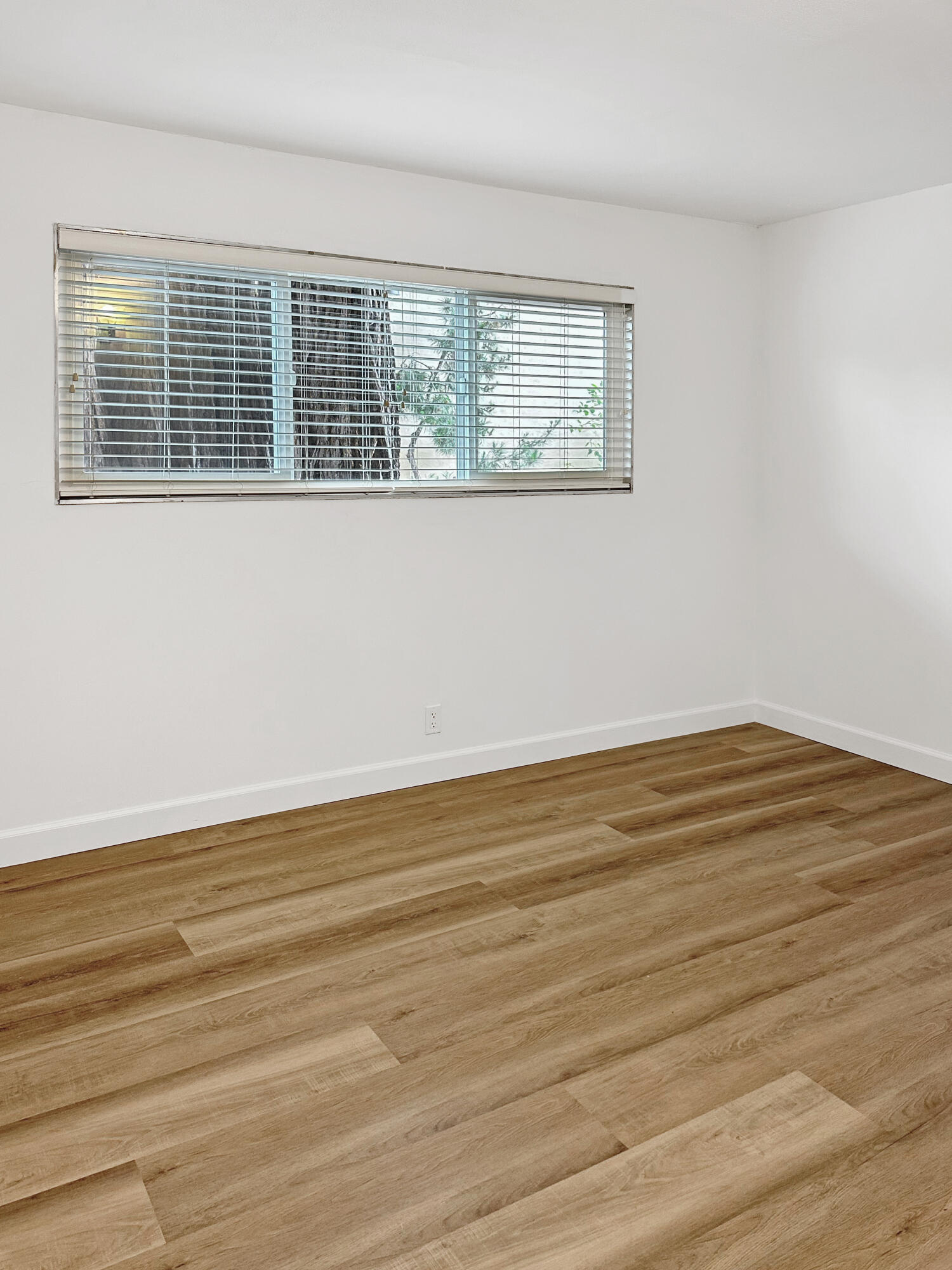 5740 Encina Road, Unit 3 Goleta, CA 93117 - Photo 13 of 23 a view of an empty room with wooden floor and a window