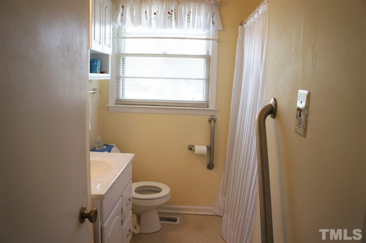 2832 Poole Road Raleigh, NC 27610 - Photo 6 of 16 a bathroom with a toilet a sink and a window