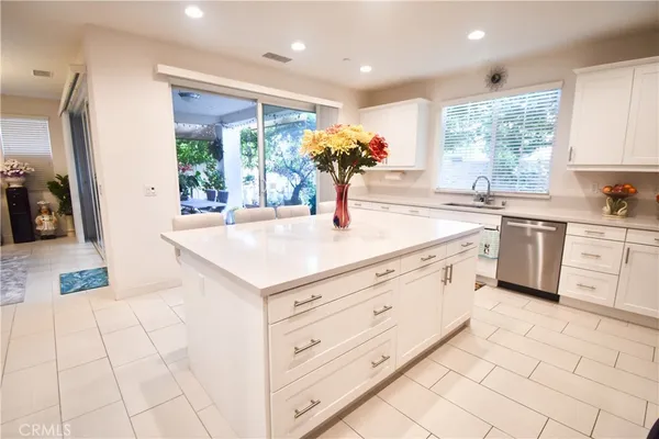 a kitchen with stainless steel appliances kitchen island granite countertop a stove refrigerator and cabinets