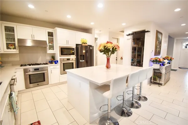a kitchen with white cabinets stainless steel appliances and sink